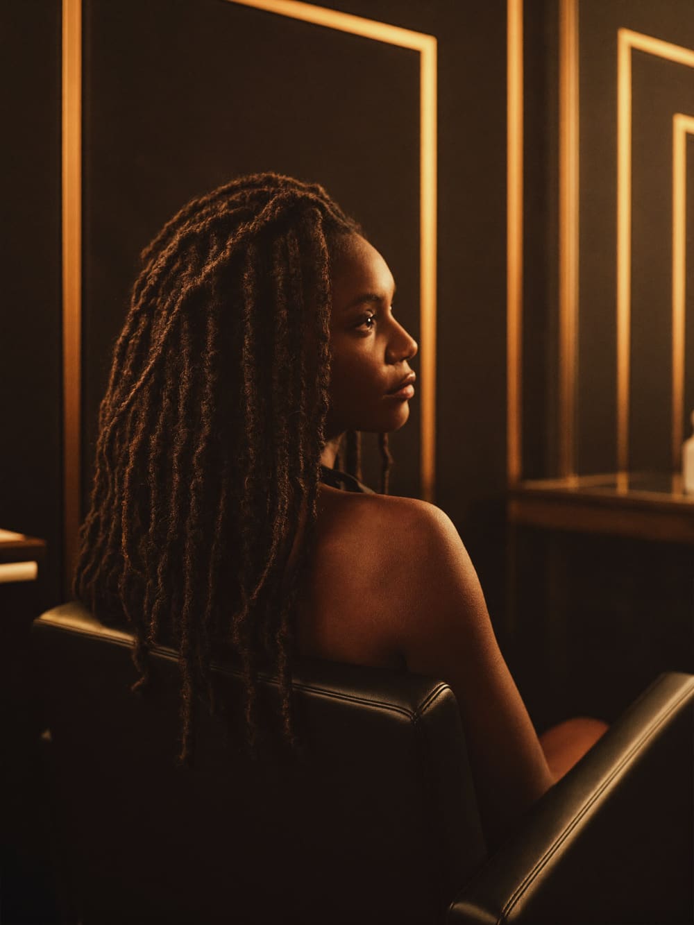 Finished locs falling over the shoulder in the salon chair